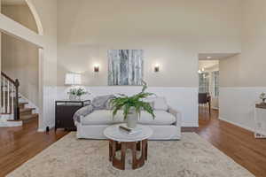 Living area with wood finished floors, a high ceiling, and recessed lighting