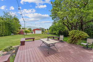 Wooden terrace with a mountain view, a yard, and an outdoor structure