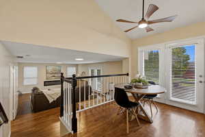 Dining room featuring wood finished floors, healthy amount of natural light, a ceiling fan, and lofted ceiling