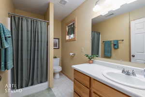Bathroom featuring a stall shower, vanity, and light tile patterned floors