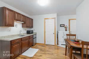 Kitchen featuring light wood finished floors, stainless steel refrigerator, and black microwave