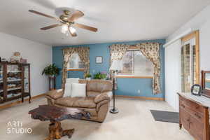 Living area featuring a ceiling fan and carpet