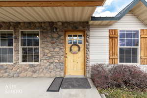 Entrance to property featuring stone siding