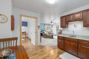 Kitchen with light wood-style floors, a ceiling fan, and open floor plan