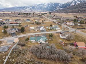 Aerial view of property and surrounding area featuring nearby suburban area and mountains