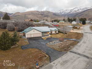 View of front of home with a mountain view, asphalt driveway, stucco siding, and an attached garage