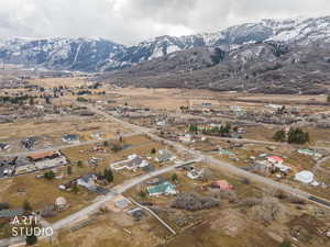 Aerial view of property and surrounding area featuring a mountain backdrop