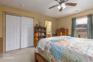 Bedroom featuring carpet flooring, ceiling fan, a closet, and connected bathroom