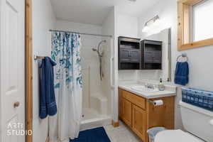 Full bathroom featuring vanity, a stall shower, and light tile patterned floors