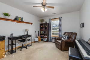 Home office featuring light colored carpet and ceiling fan