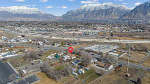 Aerial view of property and surrounding area featuring a mountain backdrop and nearby suburban area