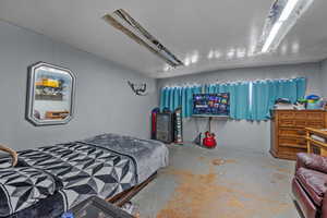 Bedroom with unfinished concrete floors