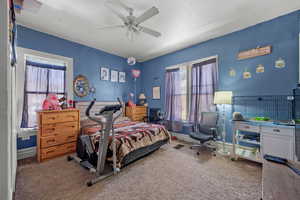 Carpeted bedroom featuring a ceiling fan and baseboards