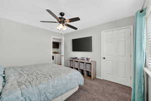 Carpeted bedroom featuring a ceiling fan and a textured ceiling