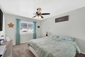 Carpeted bedroom with baseboards and ceiling fan