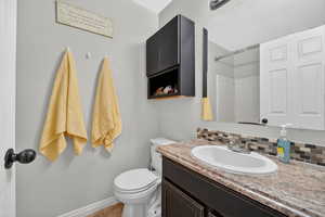 Bathroom with vanity, backsplash, and a shower