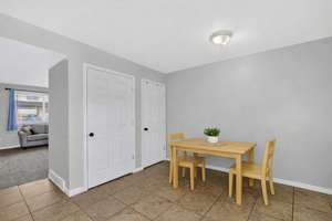 Dining area featuring tiled flooring and two paneled doors with black hardware