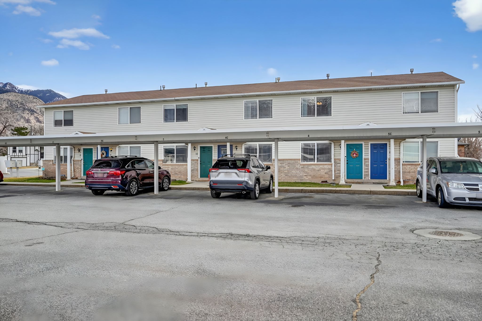 View of front of property with a mountain view, covered parking, and brick siding