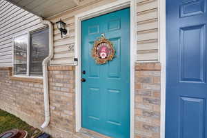 View of exterior entry with brick siding