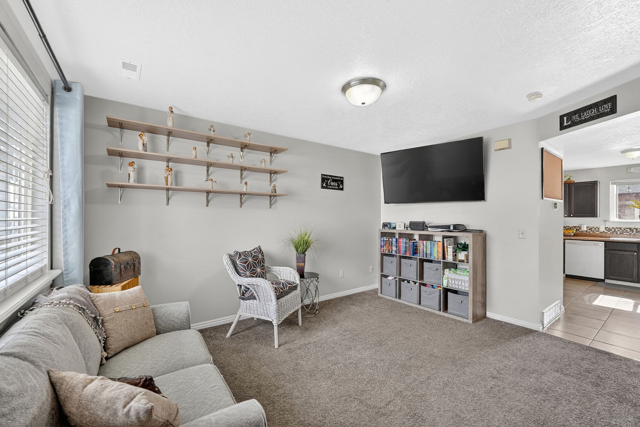 Living room featuring carpet floors, tile patterned floors, and a textured ceiling