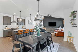 Dining area featuring light wood-style floors, lofted ceiling, recessed lighting, a ceiling fan, and a textured ceiling