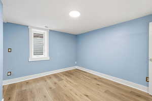 Unfurnished room featuring wood finished floors and baseboards