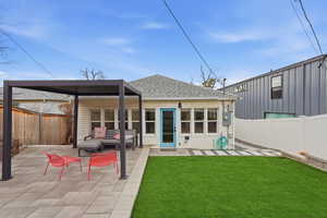 Back of house with roof with shingles, a fenced backyard, and a patio