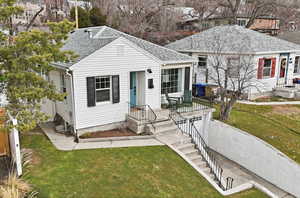 View of front of property with a front lawn, a shingled roof, and a garage