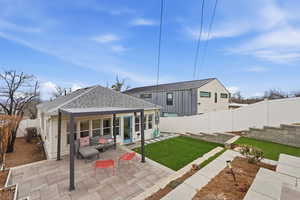 Back of house featuring roof with shingles, a fenced backyard, a patio area, and outdoor furniture
