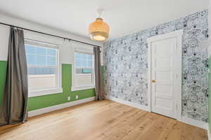 Unfurnished room with light wood finished floors and baseboards