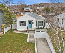 View of front of home featuring a garage, concrete driveway, a shingled roof, and a residential view