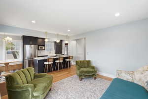 Living room with light wood-style flooring and hanging lights