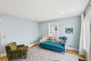 Living area with wood finished floors and recessed lighting