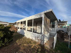 View of home's exterior featuring a sunroom and a central air condition unit