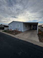 Manufactured / mobile home featuring a carport and concrete driveway