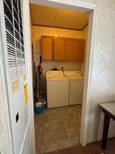 Laundry area featuring a heating unit, cabinet space, and separate washer and dryer