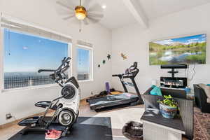 Exercise room featuring beamed ceiling, a ceiling fan, and tile patterned flooring