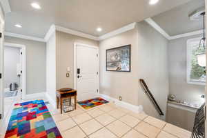 Entrance foyer featuring crown molding, light tile patterned flooring, and recessed lighting