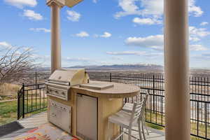 View of patio with area for grilling and a mountain view