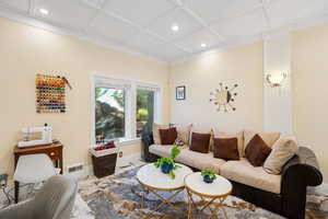 Living area featuring coffered ceiling and recessed lighting