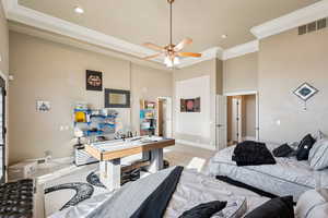 Bedroom with light wood-style flooring, ornamental molding, a high ceiling, and ceiling fan