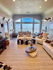 Living room featuring arched walkways, wood-type flooring, and recessed lighting