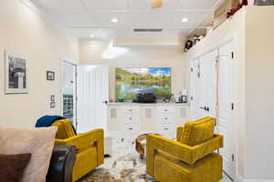 Living area with recessed lighting, coffered ceiling, and marble finish flooring