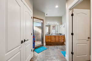 Bathroom with vanity, a shower stall, and stone finish floors