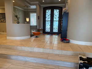 Entrance foyer with french doors, crown molding, recessed lighting, and arched walkways