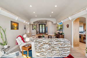 Living room with arched walkways, recessed lighting, and light wood finished floors