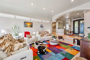 Living room featuring arched walkways, french doors, recessed lighting, and wood finished floors