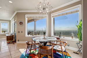Dining room featuring suspended lighting, crown molding, and light tile patterned floors