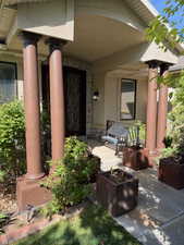View of exterior entry with stone siding and stucco siding