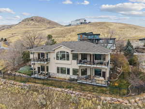 Back of house featuring a fenced backyard, a mountain view, and a patio